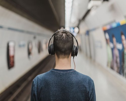 Person listening to headphones on public transport